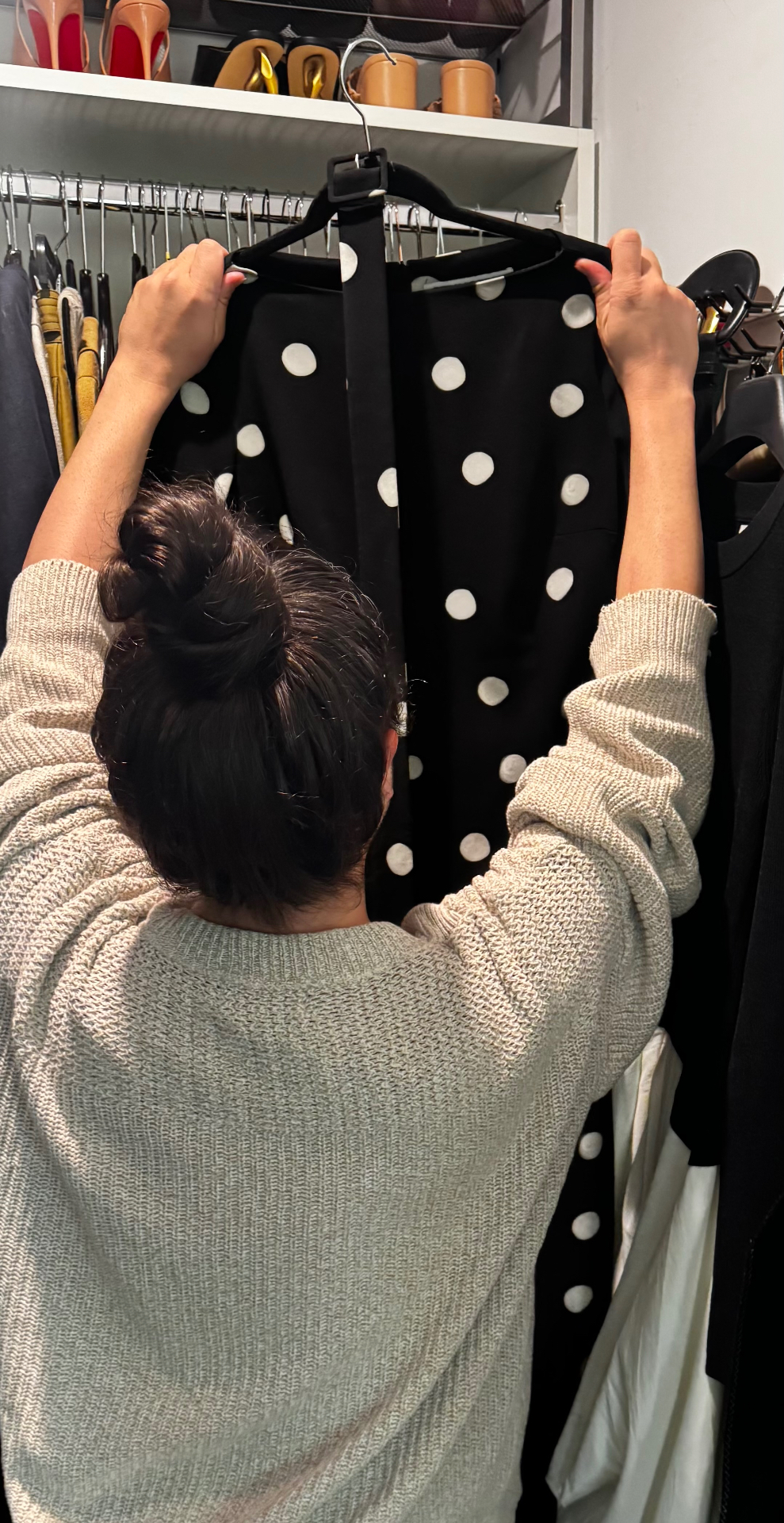 Carwin Brice organizing a polka-dot dress in a closet