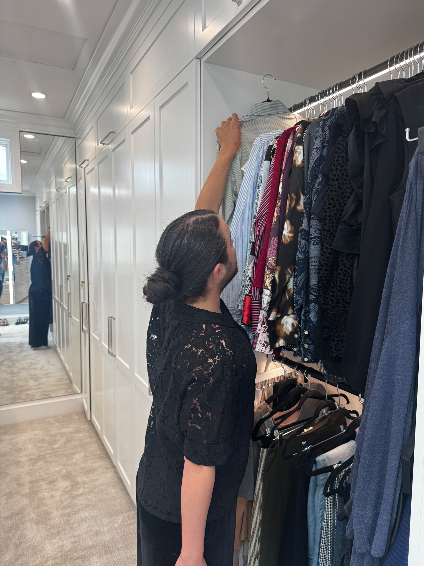 Carwin Brice styling a client's wardrobe during an in-home closet edit