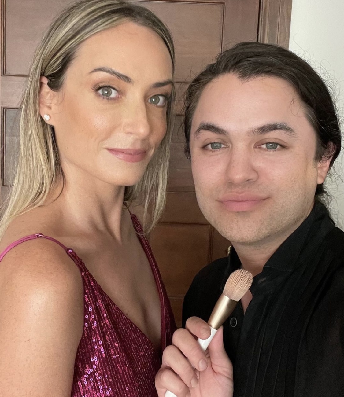Carwin Brice with client in pink sequin dress holding makeup brush