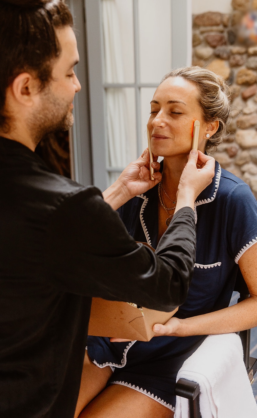 Carwin Brice doing skincare prep on client in navy pajamas